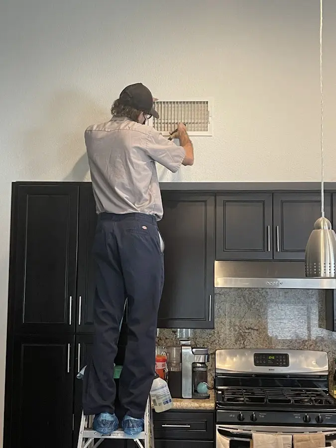 Technician inspecting an air vent during HVAC service in Rapid Valley